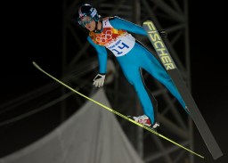 Un skieur effectue un saut depuis le grand tremplin aux Jeux olympiques de Sotchi 2014