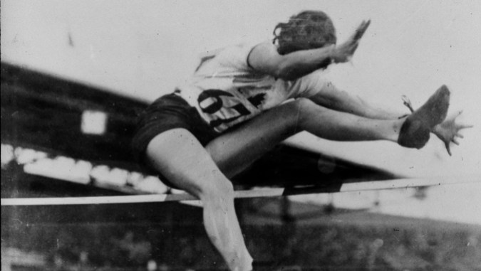 Équipe-canada-ethel-catherwood-e1551375971997 Une sauteuse en hauteur passe par dessus la barre en effectuant un coup de ciseaux aux Jeux olympiques de 1928