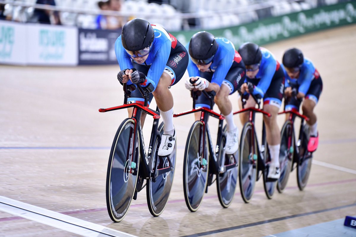 quatre femmes se suivent lors d'une course de poursuite par équipes dans un vélodrome