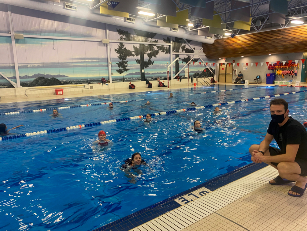 Un entraîneur sur le bord de la piscine.