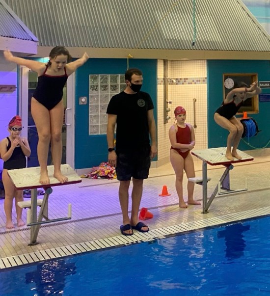 Équipe Canada Con Kudaba Chinook Swim Club 2020 Un entraîneur sur le bord de la piscine.