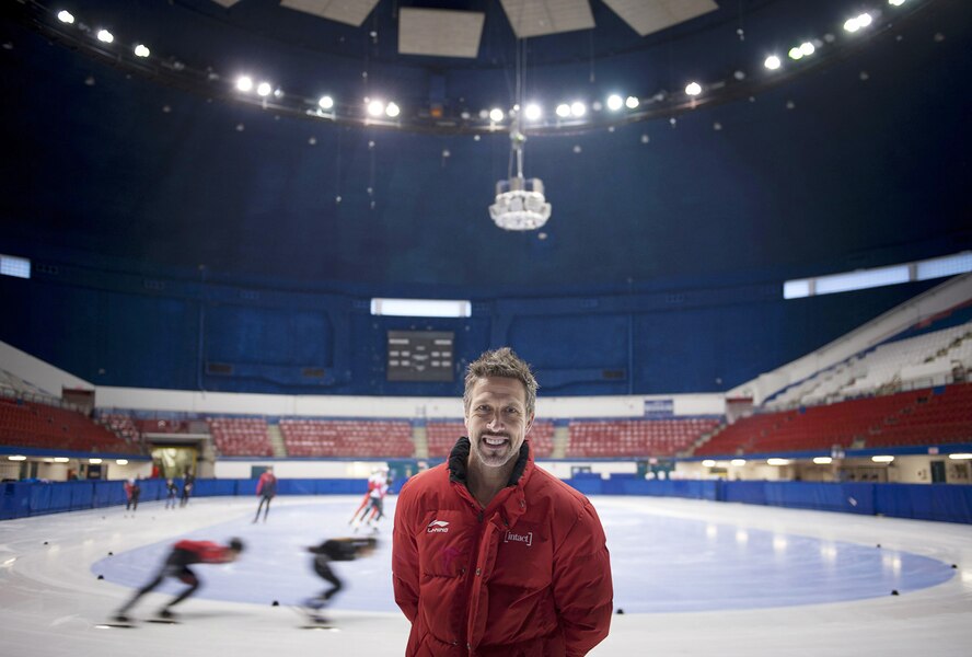 Un entraîneur pose devant une glace de patinage de vitesse sur courte piste