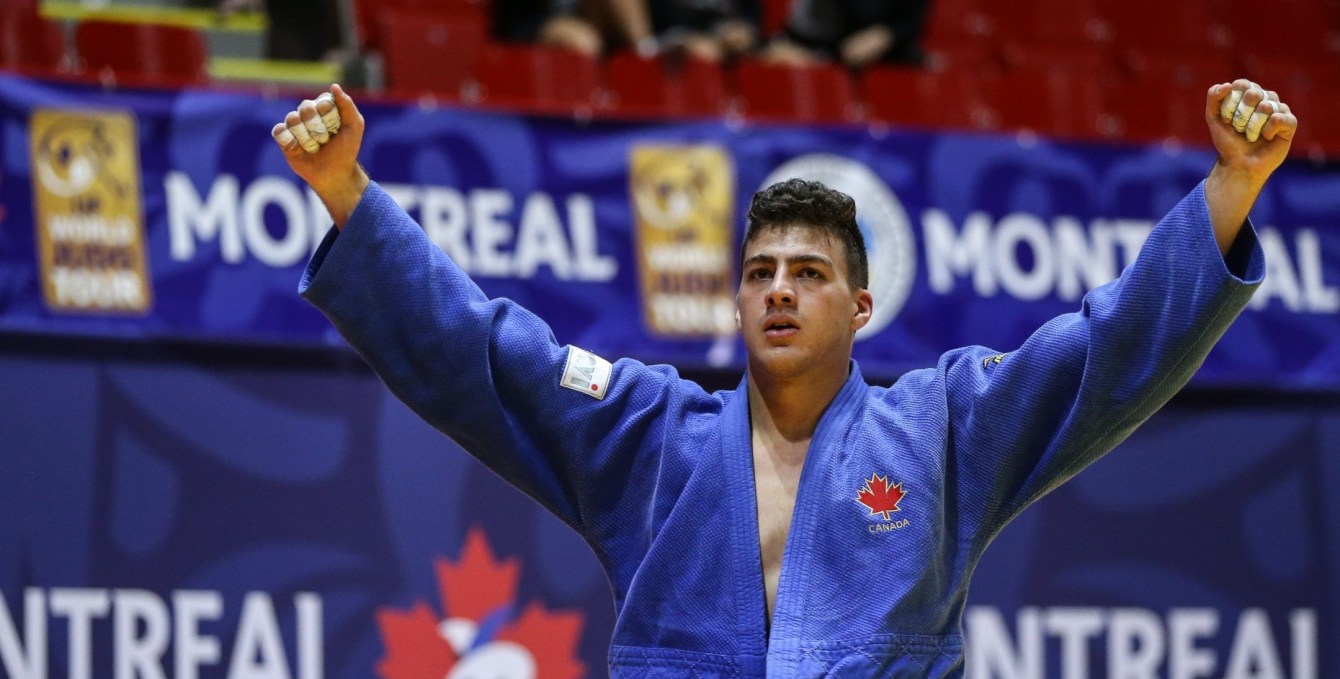 Un judoka lève les bras en signe de victoire