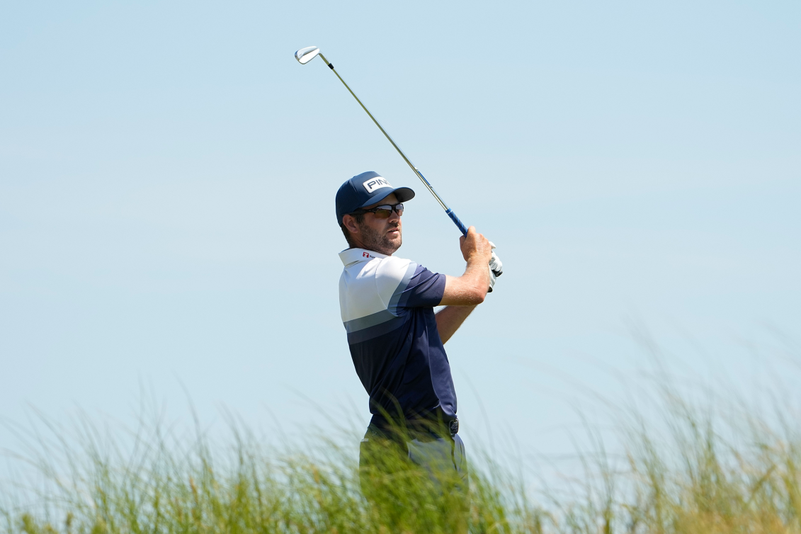 Un joueur de golf regarde sa balle filer