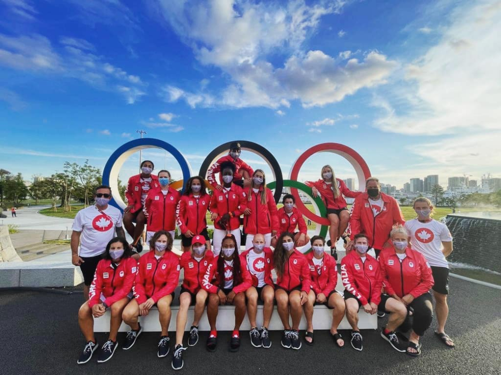 L'équipe féminine de rugby à sept pose devant les anneaux olympique au Village olympique.