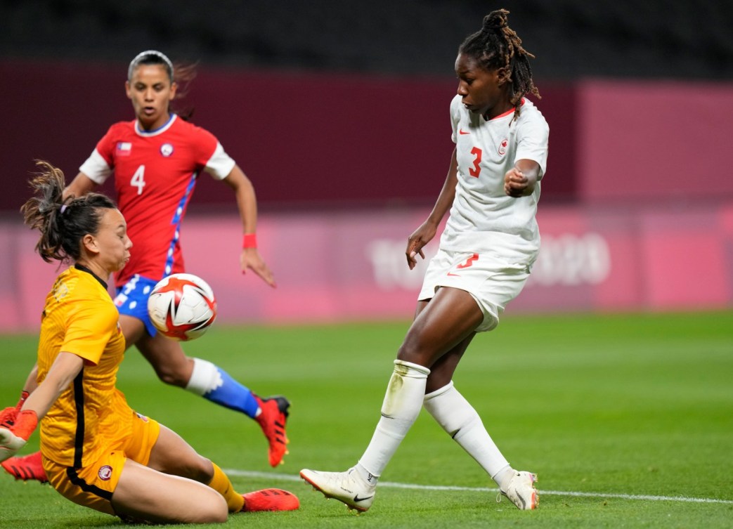 Kadeisha Buchanan du Canada frappe le ballon dans la poitrine du gardien chilien alors qu'elle glisse pour le bloquer.