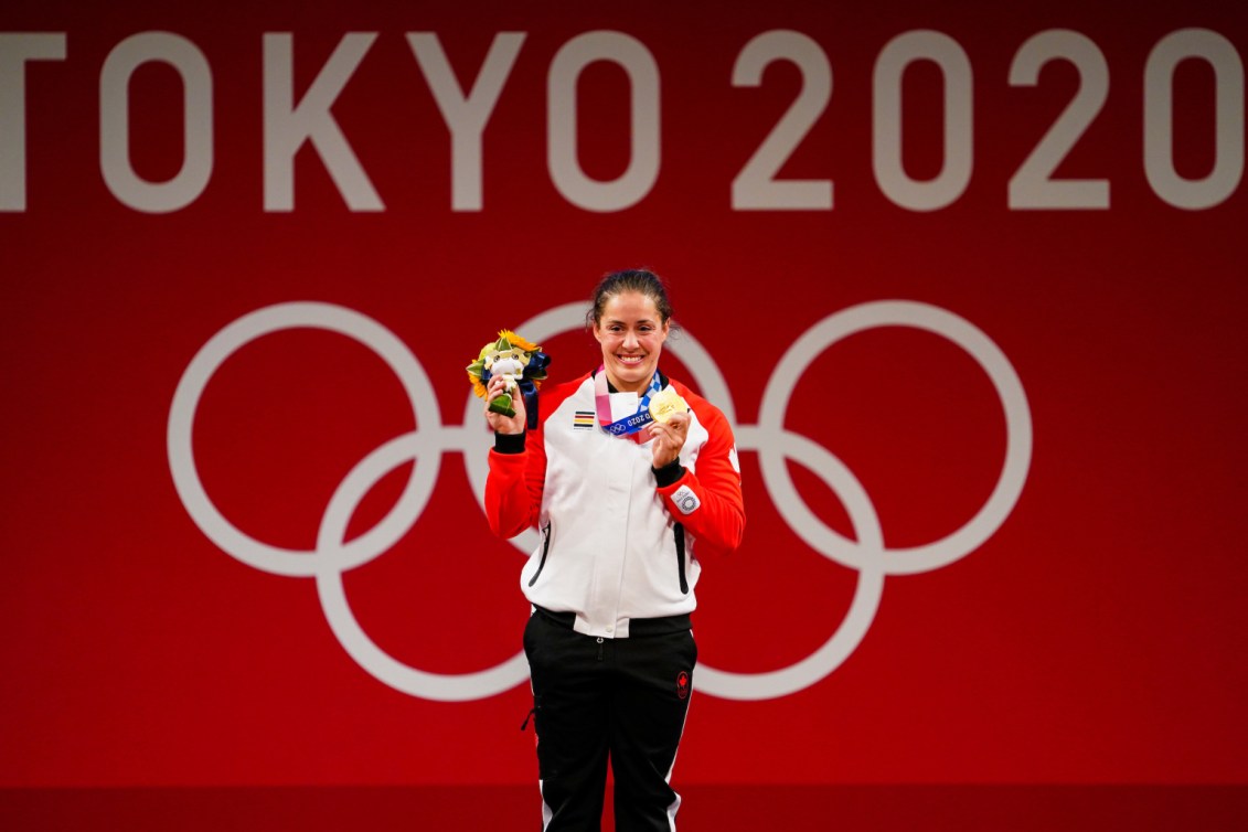 Une haltérophile canadienne montre sa médaille d'or sur le podium