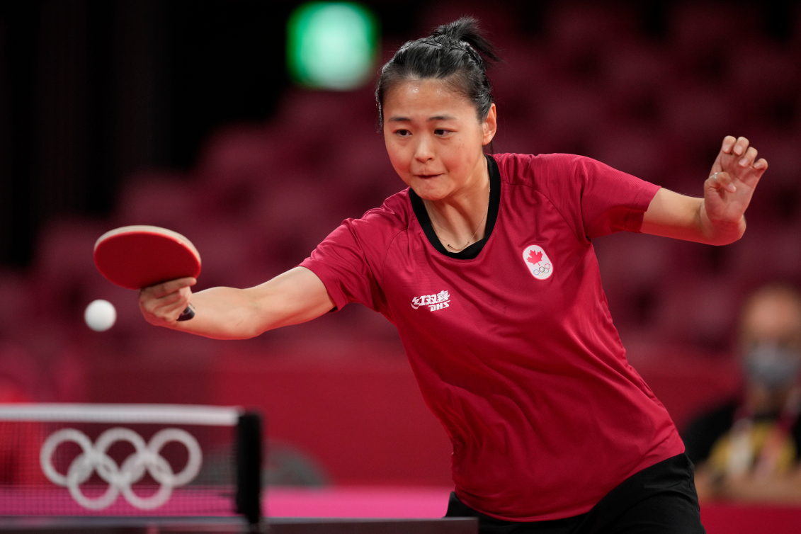 Mo Zhang pendant un match de tennis de table.