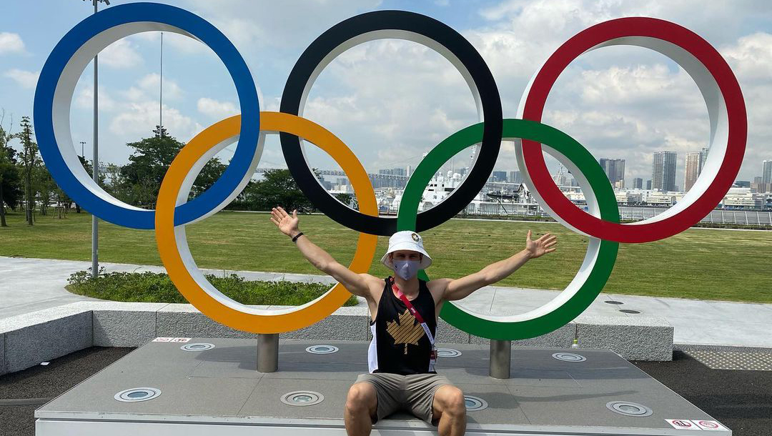 Vincent Riendeau pose devant les anneaux olympique au village des athlètes.