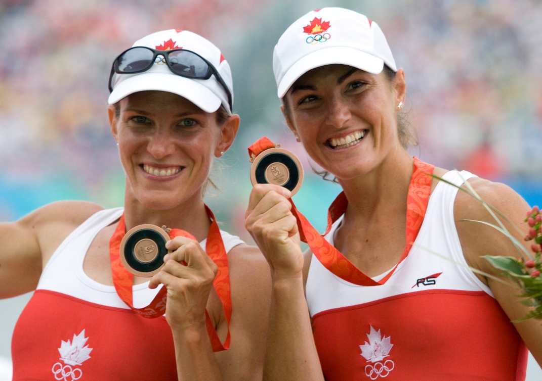 Deux athlètes présentent leur médaille de bronze à la caméra.