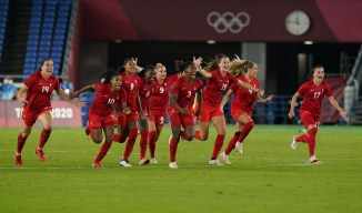 des joueuses célèbrent sur le terrain de soccer.
