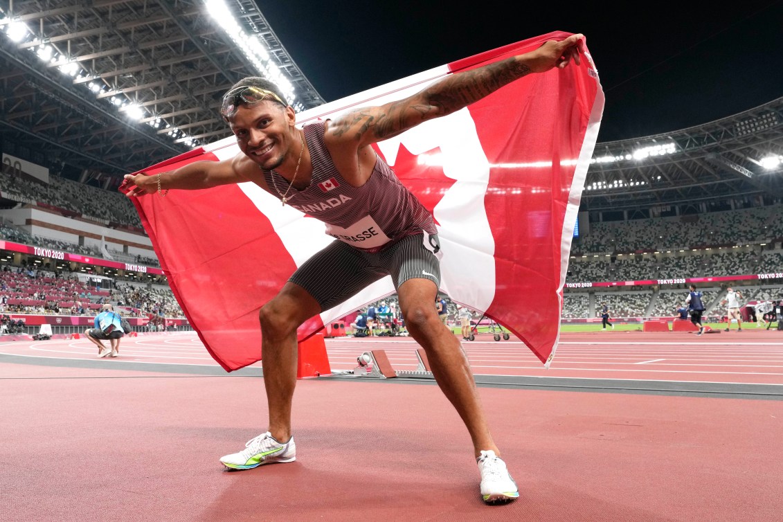 Andre De Grasse pose avec le drapeau canadien.