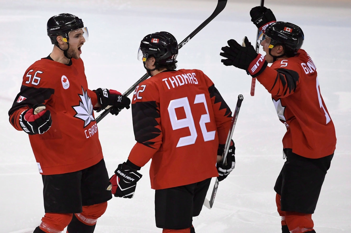 Trois joueurs de hockey célèbrent un but