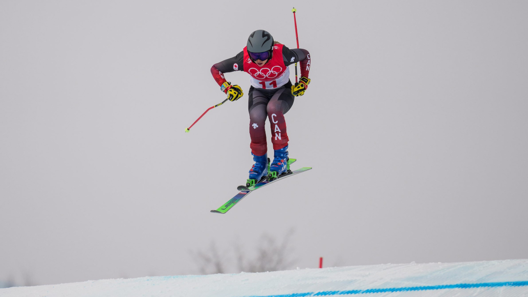 Une skieuse en plein saut lors d'une descente de ski cross