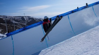 Une skieuse effectue un saut sur la demi-lune
