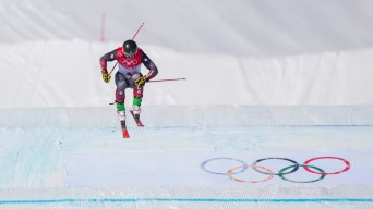 Un skieur effectue un saut lors d'une descente de ski cross