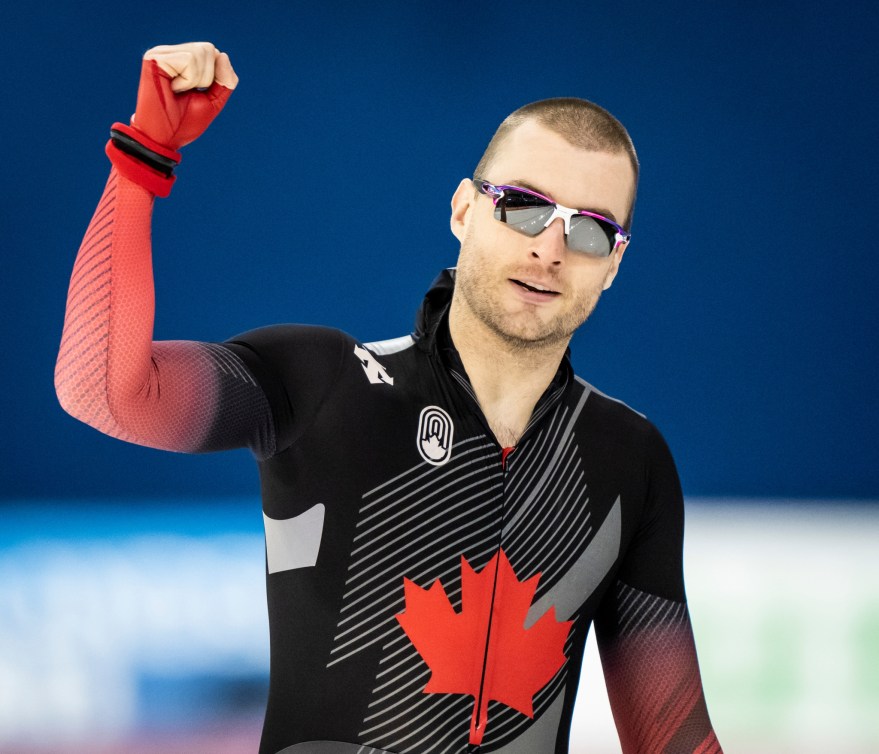 Un patineur de vitesse lève le poing en signe de victoire