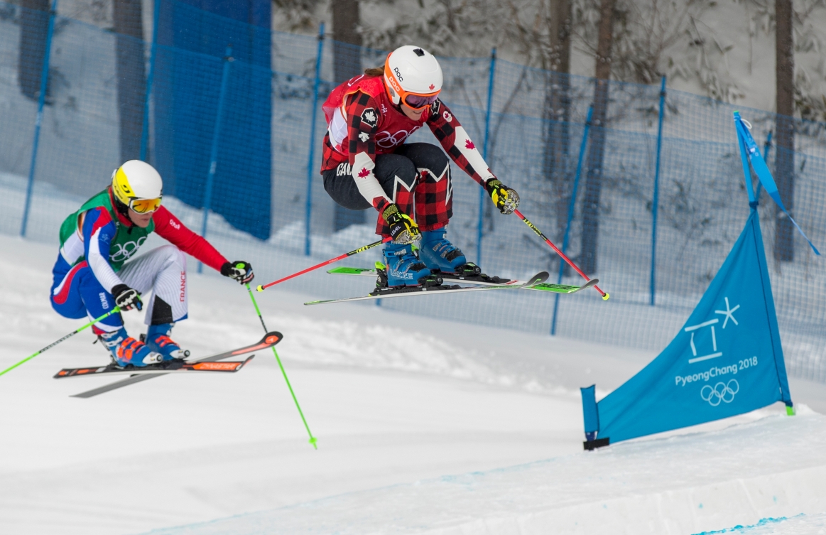 Deux skieuses de ski cross effectuent un saut