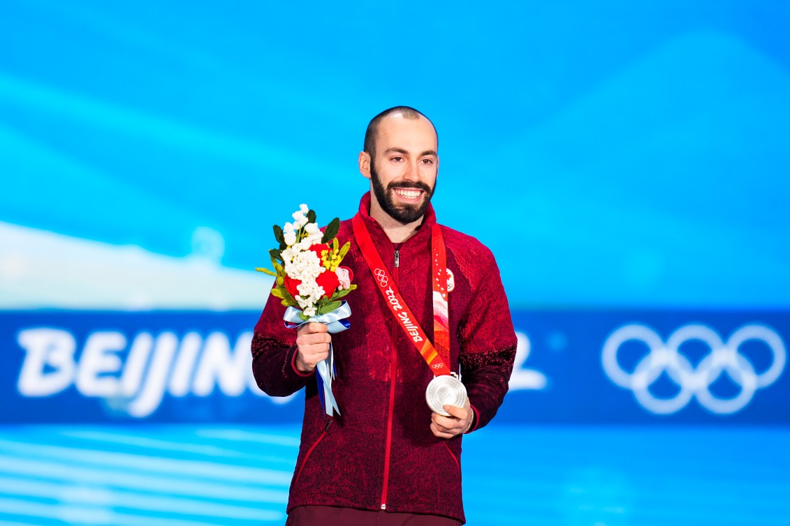 Steven Dubois une médaille d'argent autour du cou et dans la main gauche et des fleurs dans la main droite.