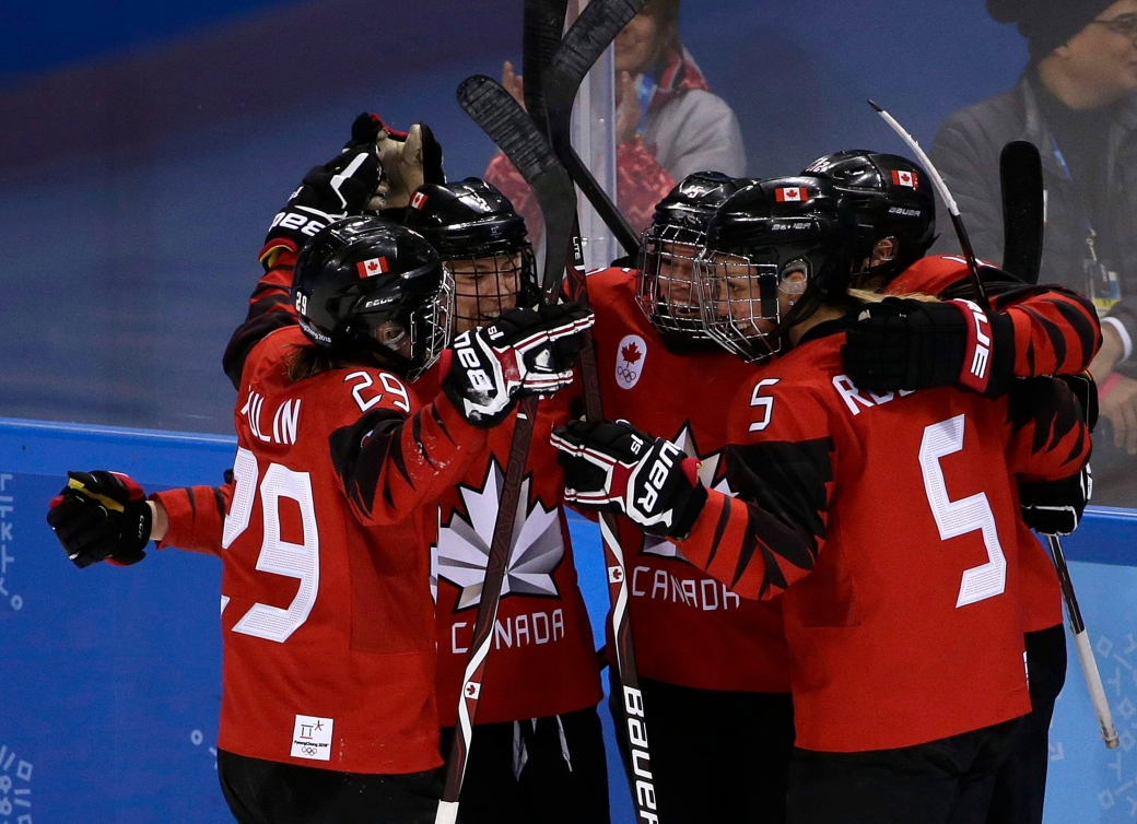 Cinq hockeyeuses célèbrent après un but.