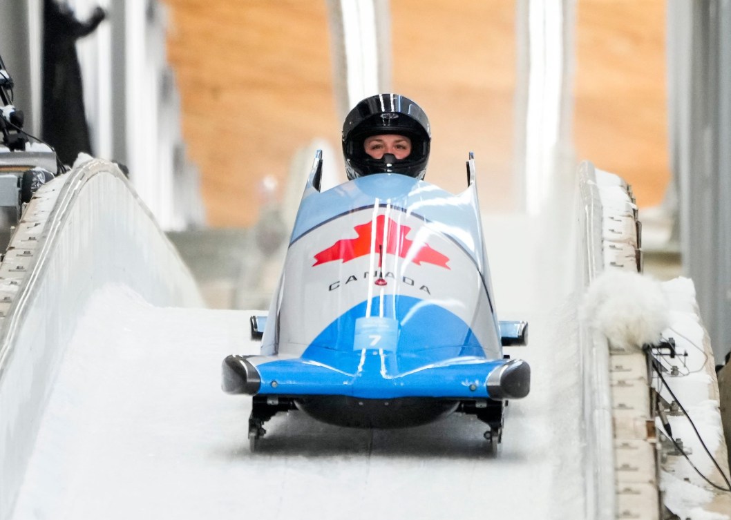 La bobeuse Christine de Bruin d'Équipe Canada a la visière levée et est toujours dans son bobsleigh à l'arrivée d'une descente en monobob à Beijing 2022.