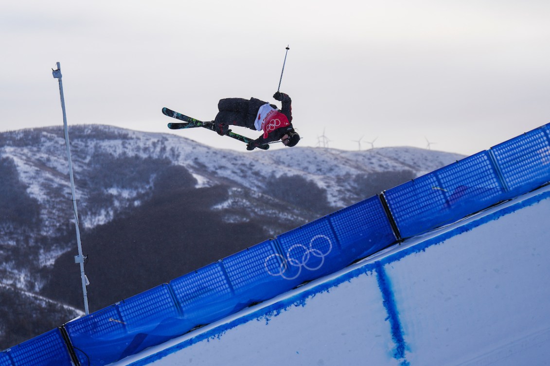 La skieuse acrobatique d'Équipe Canada Cassie Sharpe effectue une manoeuvre dans les airs en prenant l'arrière de son ski à la demi-lune à Beijing 2022.