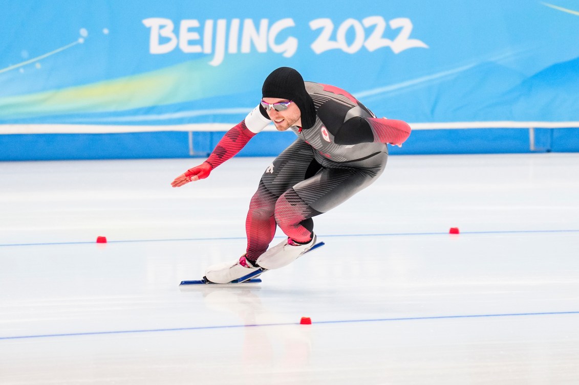 Le patineur de vitesse longue piste d'Équipe Canada Laurent Dubreuil participe à l'épreuve masculine du 500 m. Il est accroupit, en pleine course.