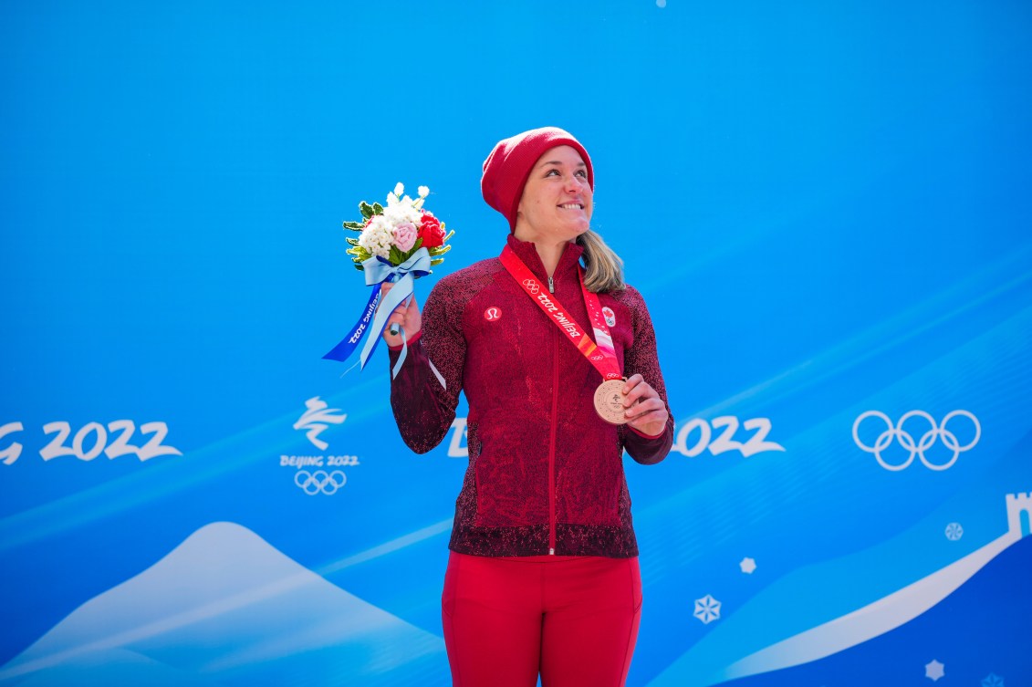 Christine de Bruin sur le podium avec la médaille de bronze autour du cou et les fleurs dans la main droite.