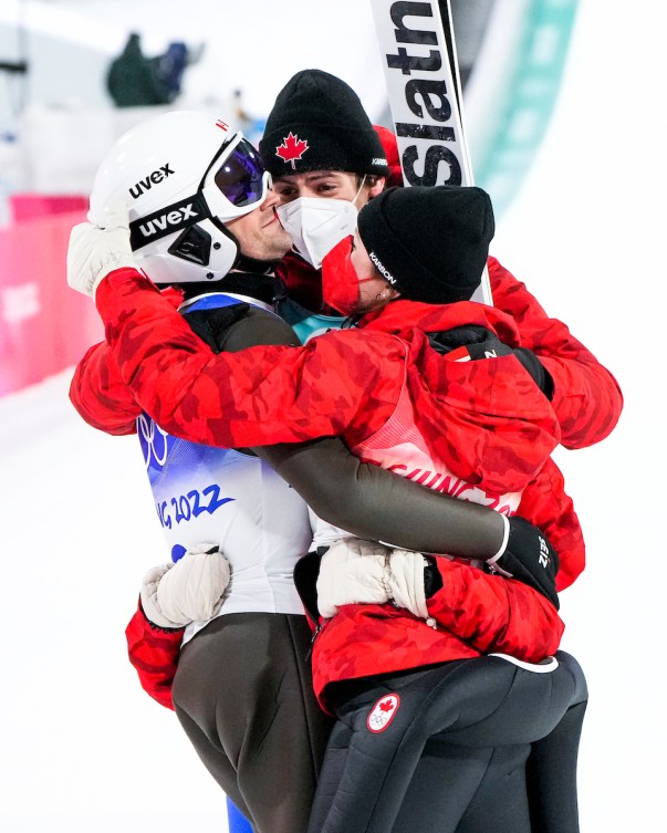 Les quatre médaillés de bronze à l'épreuve mixte par équipes en saut à ski se font un câlin