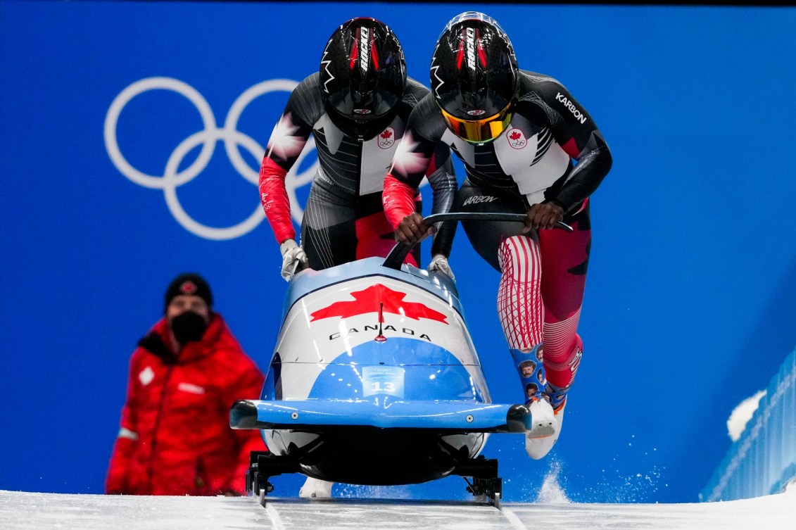 Cynthia Appiah et Dawn Richardson Wilson poussent leur bob et s'apprêtent à y embarquer lors de la série de trois de bobsleigh féminin à deux de Beijing 2022