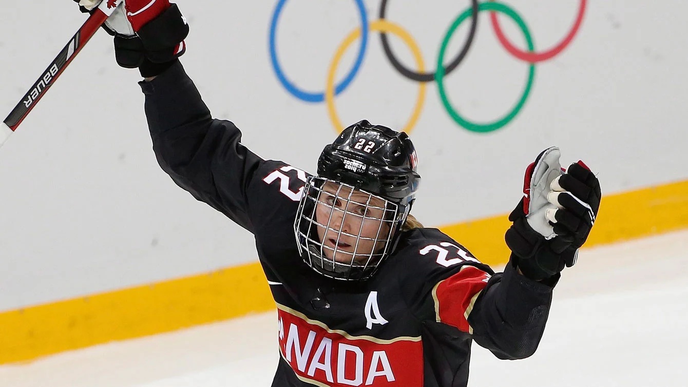 Une hockeyeuse lève les bras dans les airs.