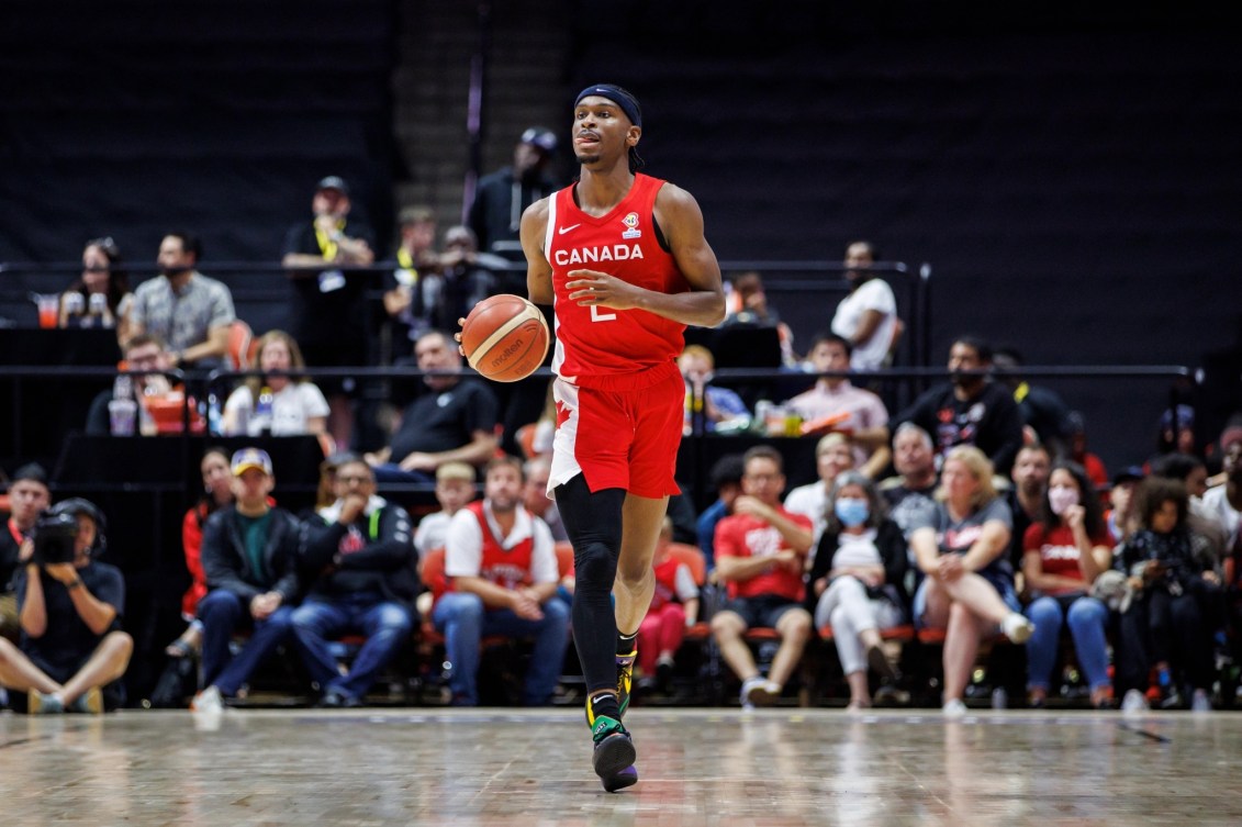 Un joueur de basketball dribble sur le terrain. 