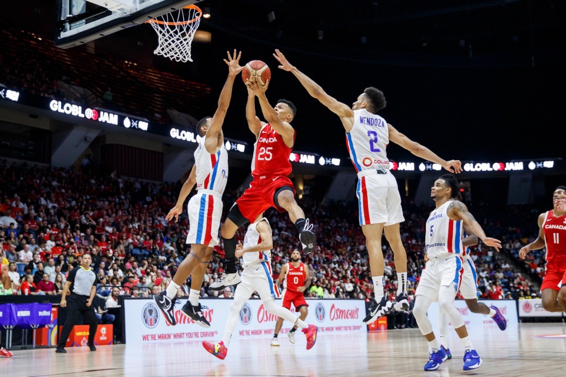 Trae Bell-Haynes (25) saute vers le panier entre deux joueurs.