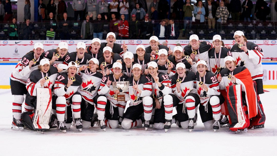 Les joueuses de hockey canadiennes posent avec le trophée du Championnat du monde 2022.