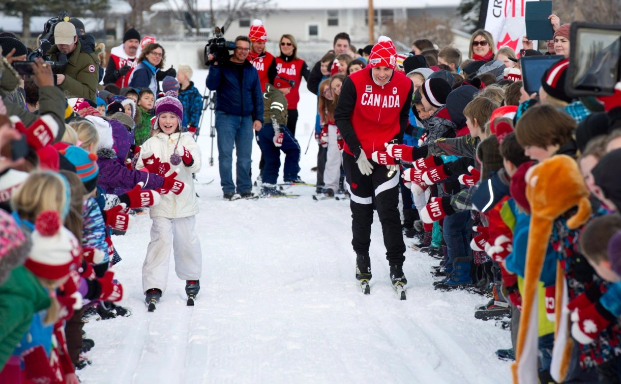 L'athlète de ski de fond Jesse Cockney, au centre, et l'élève de troisième année Tess Waters, âgée de 8 ans, participent à une courte course amicale de ski de fond. 