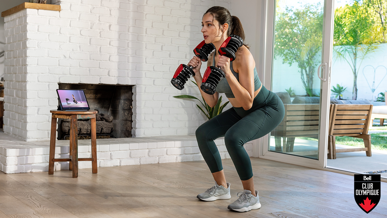 woman doing a squat with dumbbells