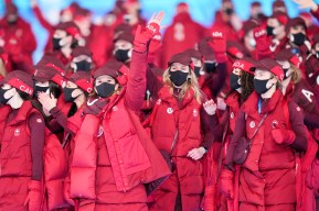 Des athlètes klors de la cérémonie d'ouverture des Jeux de Beijing 2022 avec des manteaux rouges.