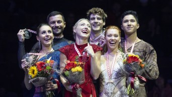 Trois équipes de danse sur glace rient sur le podium