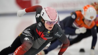 La patineuse Kim Boutin en action dans un virage à une épreuve de patinage de vitesse courte piste.