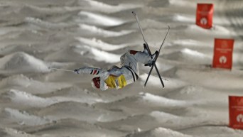 Mikaël Kingsbury effectue un saut sur le parcours de bosses.