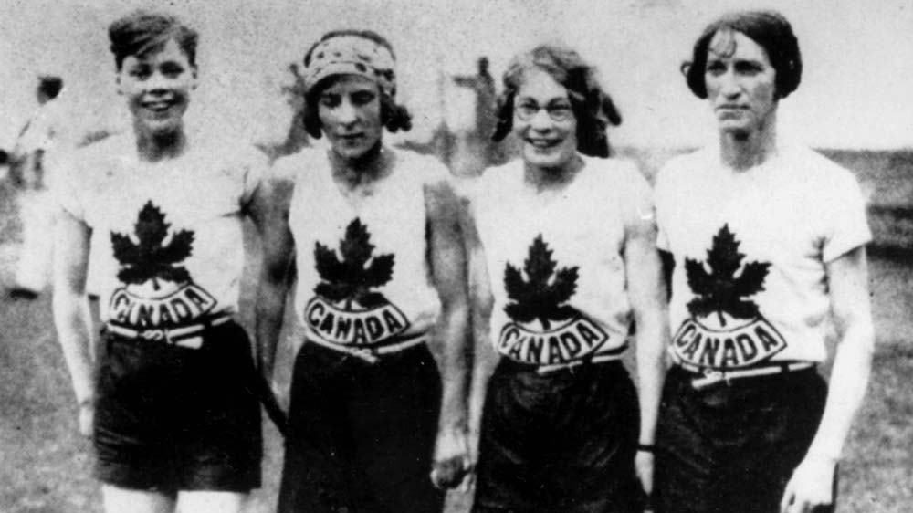 Photo en noir et blanc de quatre femmes en tenue de sport.