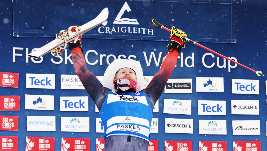 Brady Leman soulève ses skis pour célébrer.