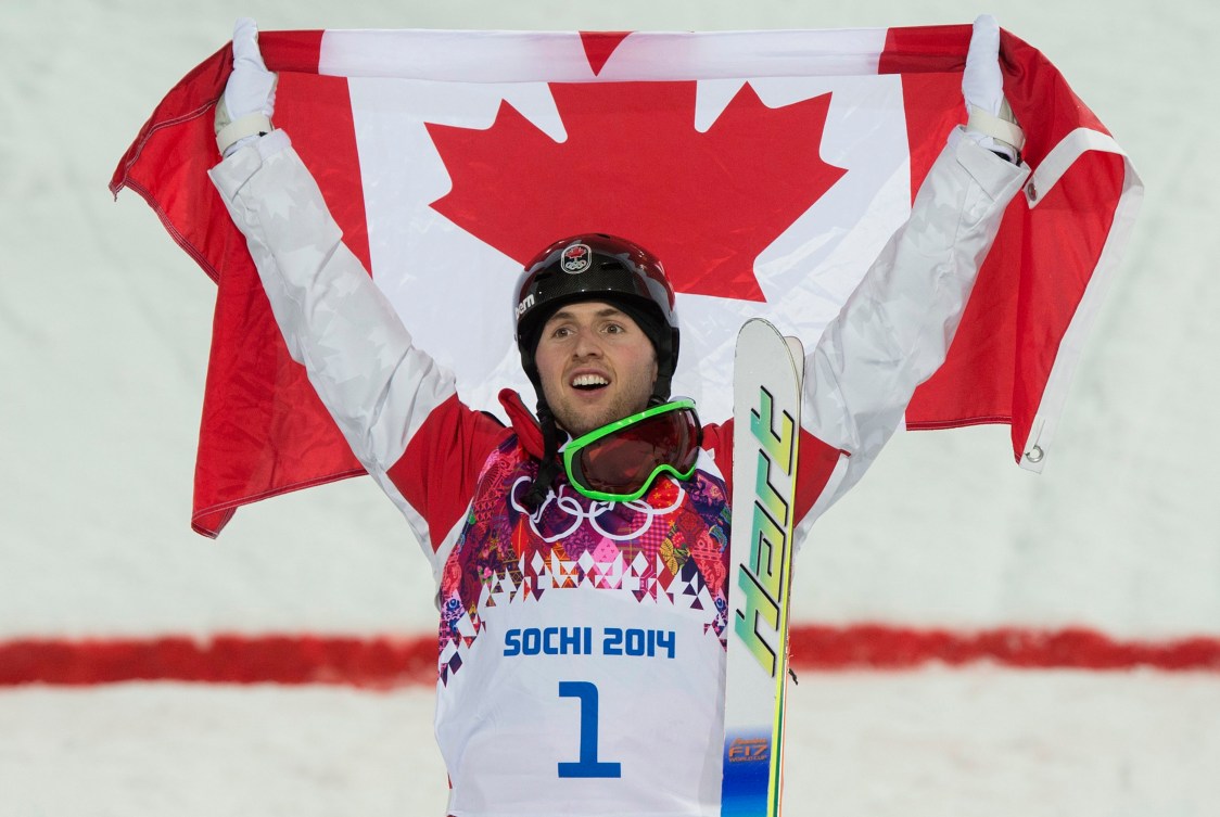 Alexandre Bilodeau lève les bras dans les airs.