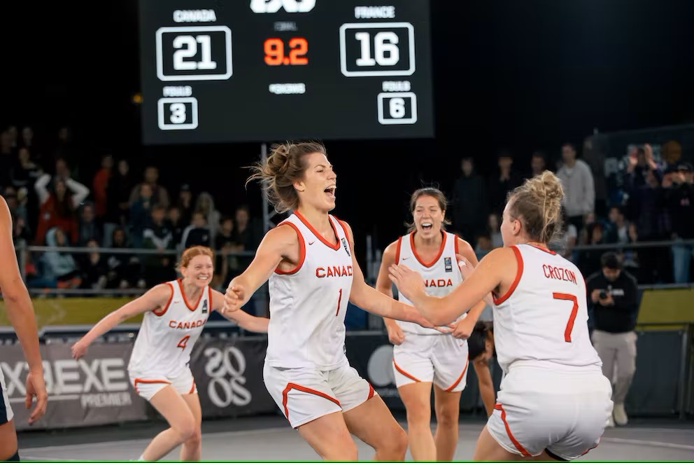 Des joueuses de basketball célèbrent sur le terrain. 