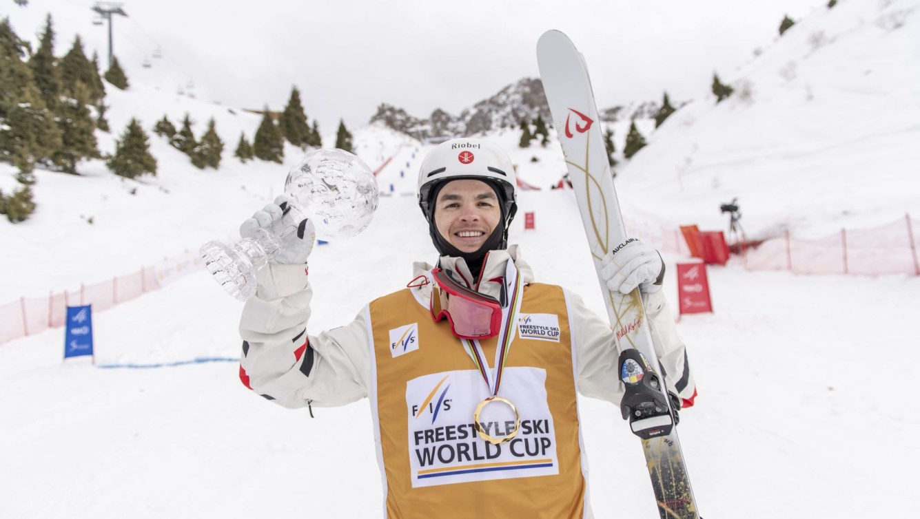 Mikaël Kingsbury tient un globe de cristal dans la main droite.