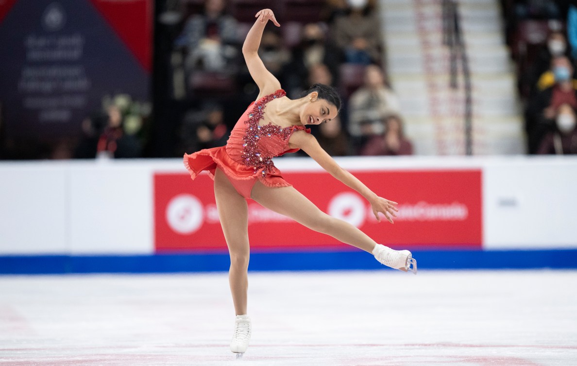 Madeline Schizas sur la glace dans une robe orange.