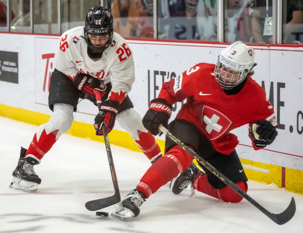 Deux joueuses de hockey près de la bande. 