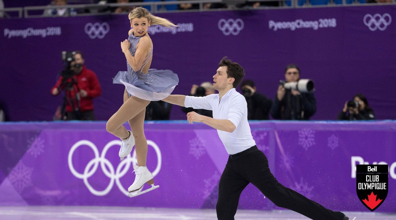 Female skater in air as male skater skates on ice