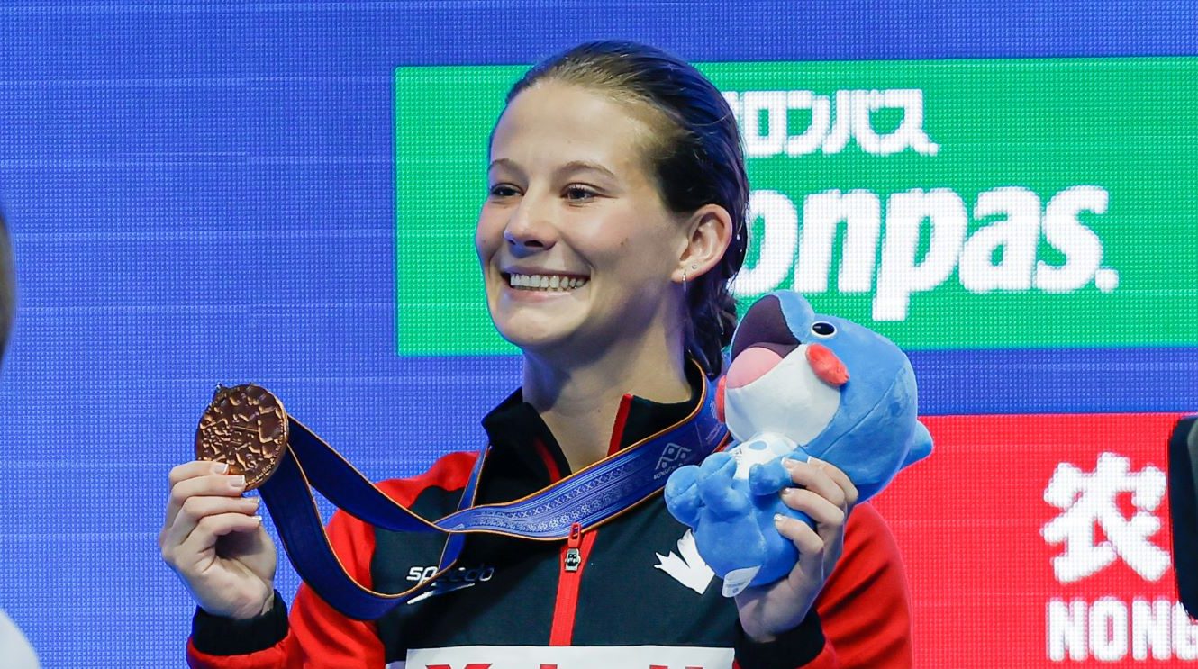 Caeli McKay posent avec la médaille de bronze.