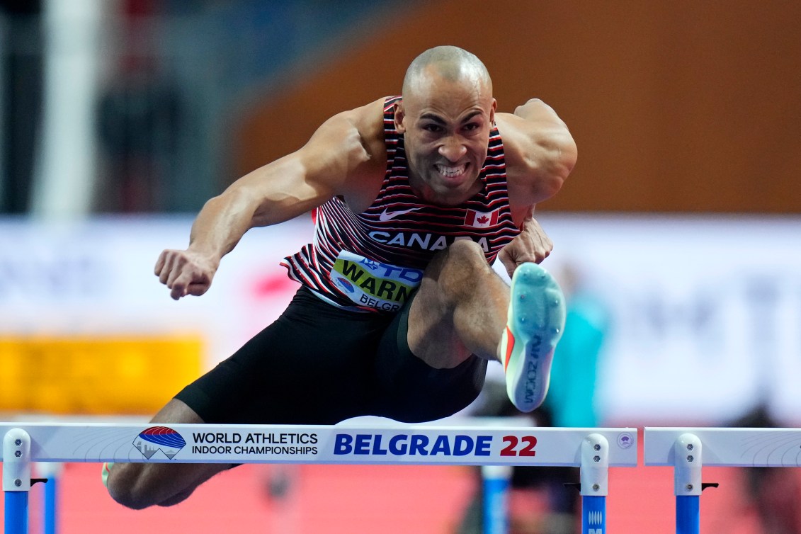 Damian Warner saute une haie. 